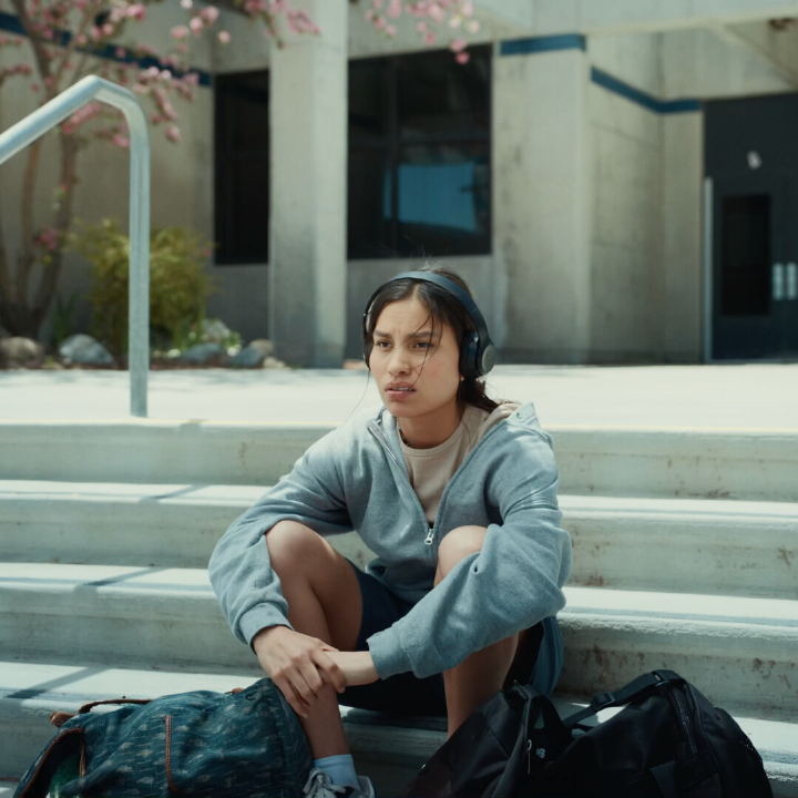 Person sits outside on steps looking off.